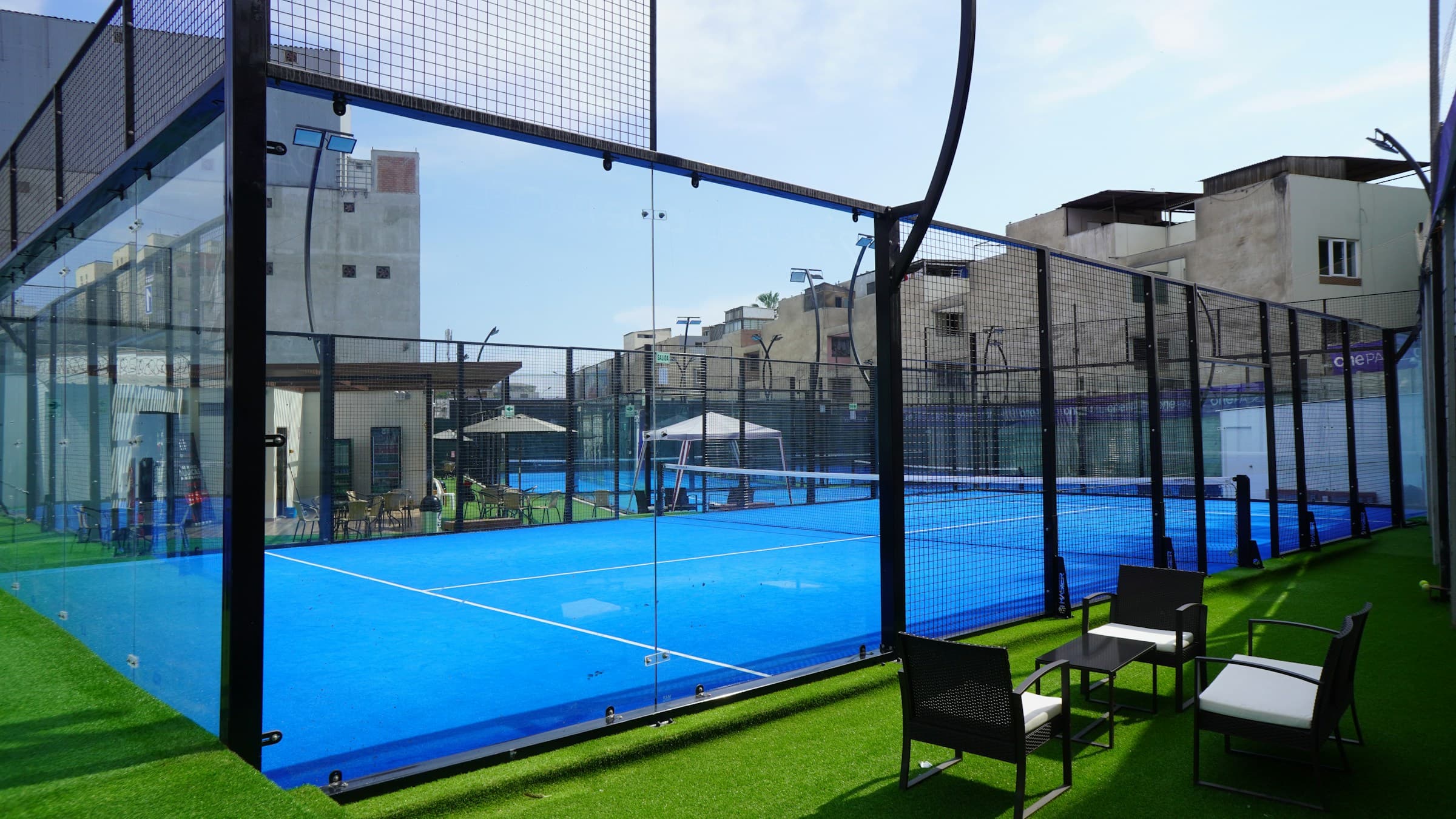 Full-size padel court with glass walls and floodlighting
